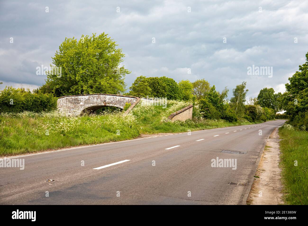 Overgrown arch bridge 164 with deserted A533 between Sandbach and Middlewich Cheshire UK Stock Photo