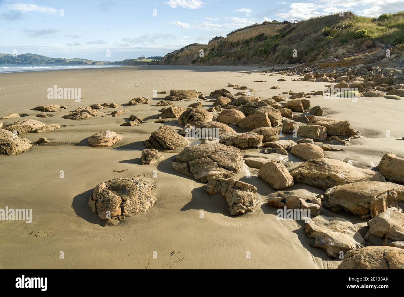 Large boulders and stone of different shapes and sizes including the Moeraki Boulders lay on Koekohe Beach, Otago, South Island, New Zealand Stock Photo