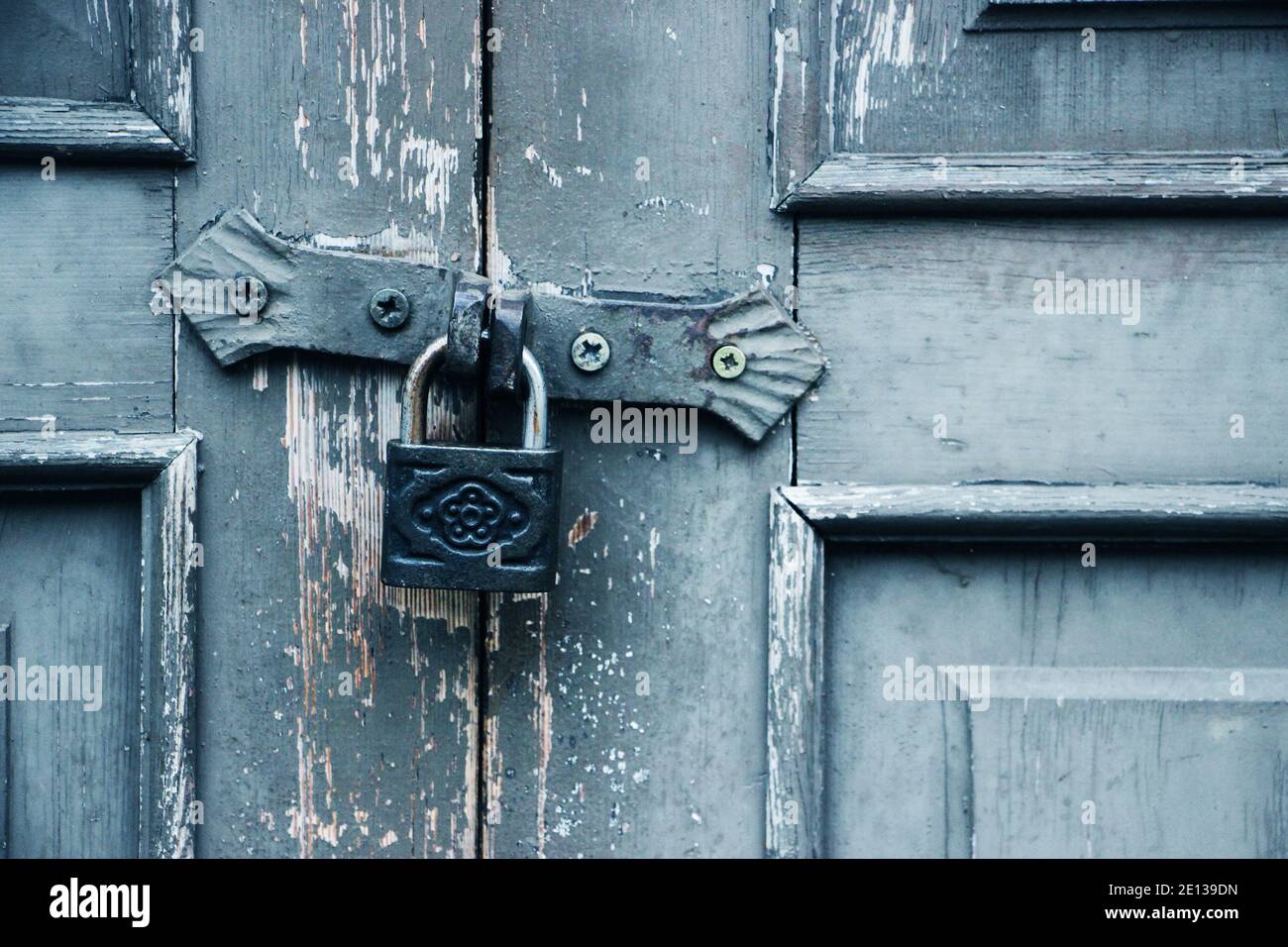 Hangig vintage padlock on locked old wooden door. Forbidden protected