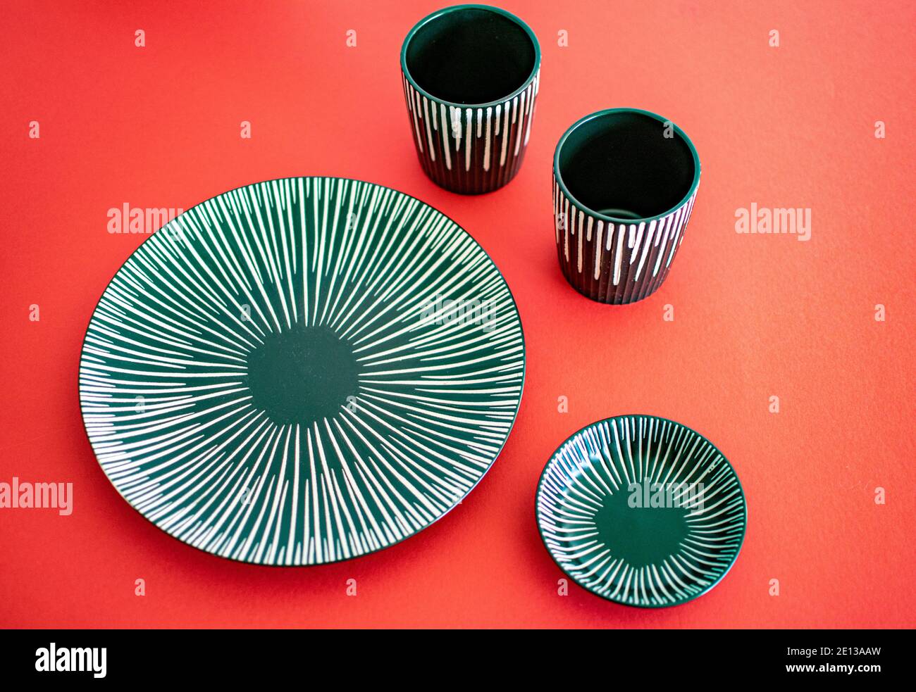 a grey ceramic plate set on a red background landscape Stock Photo