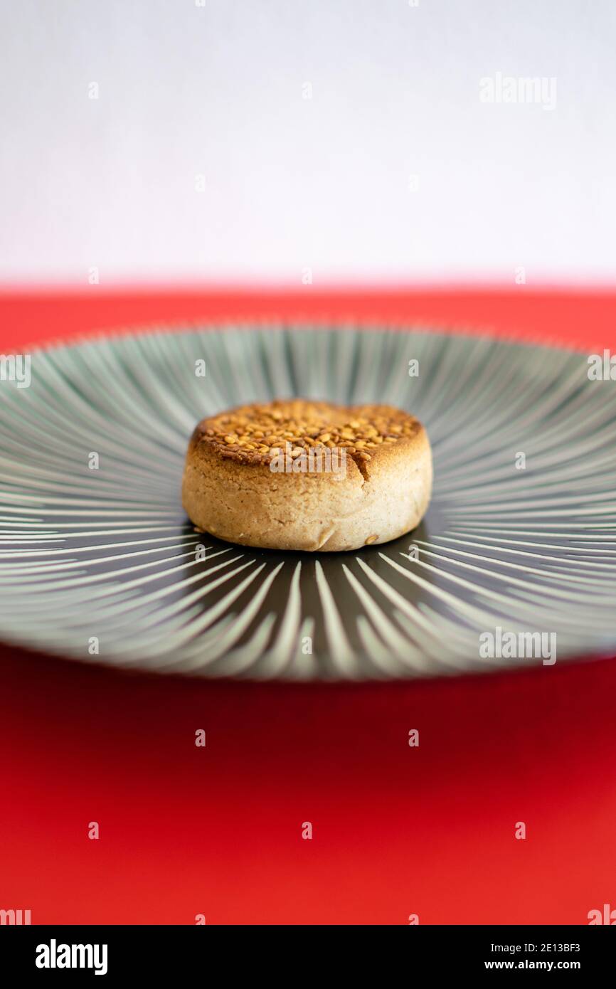 a single traditional Spanish Christmas sweet called a Mantecado on a plate Stock Photo