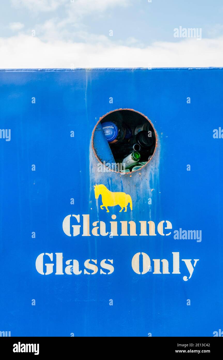 A glass recycling bin on Barra in the Outer Hebrides with the Gaelic word for glass, Glainne, on the side. Stock Photo