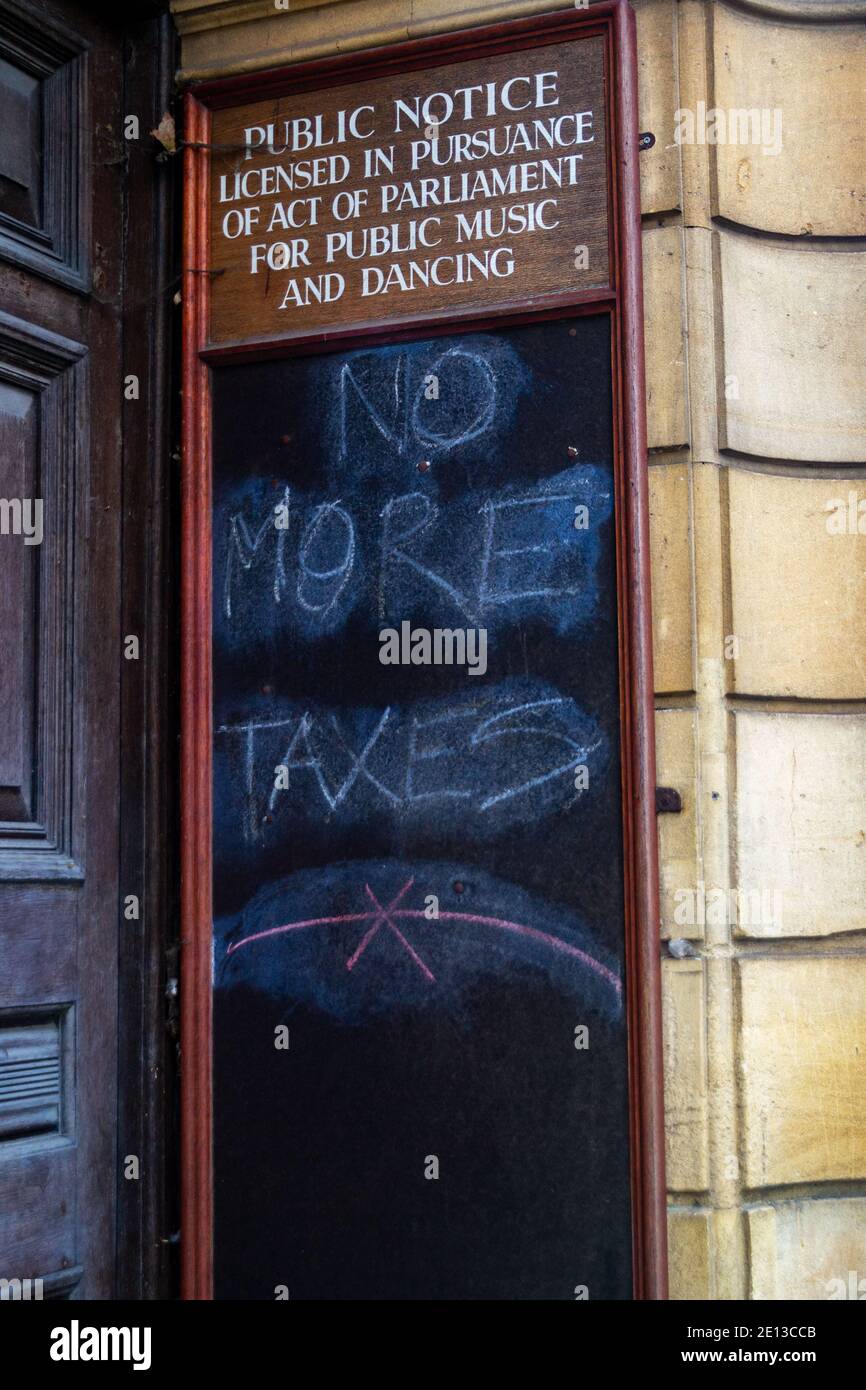 'No More Taxes' written in chalk on a town hall noticeboard, Leamington Spa, Warwickshire, England, United Kingdom Stock Photo