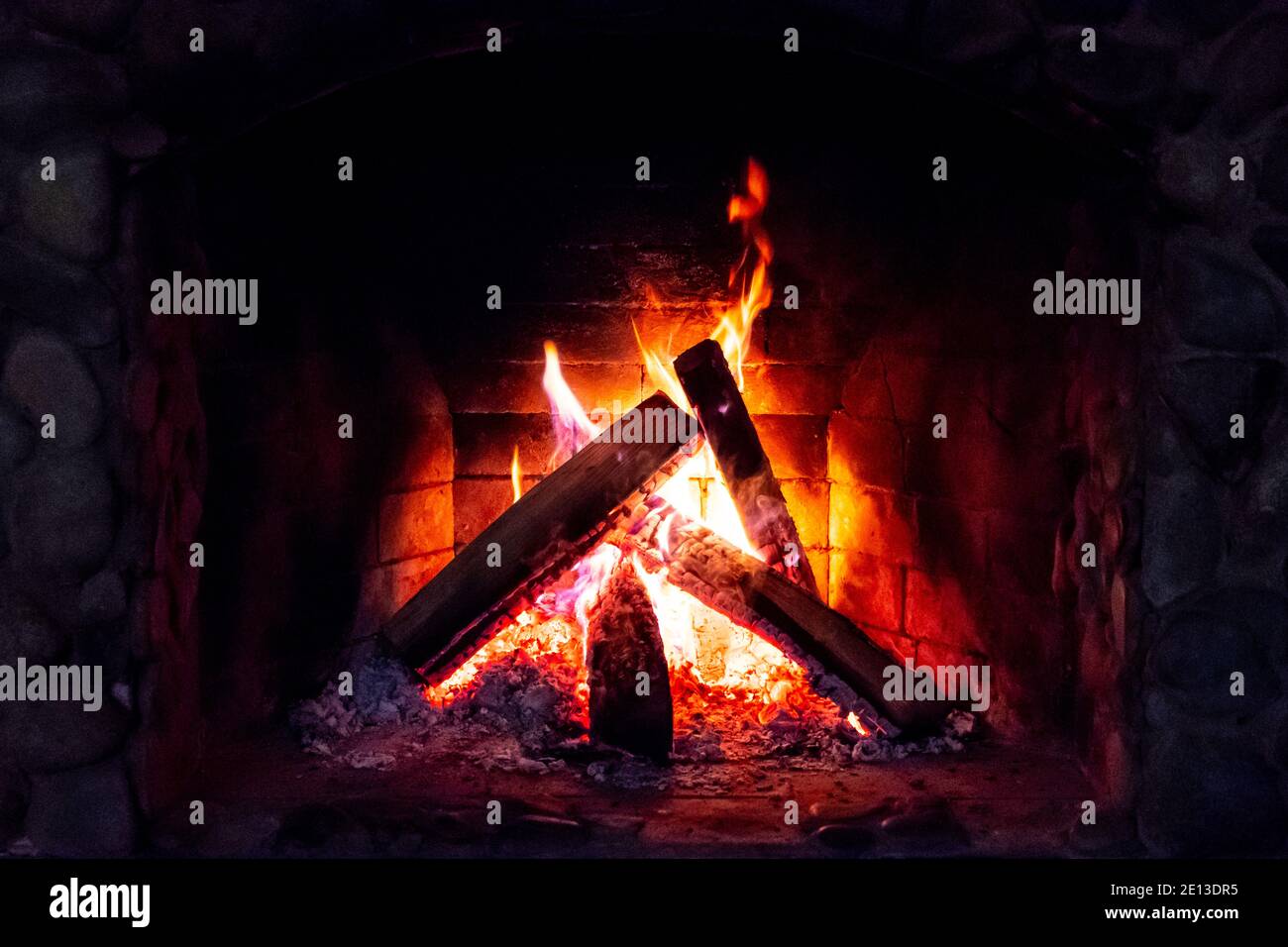 Flames in the fireplace. Burning wood. Brick fireplace Stock Photo