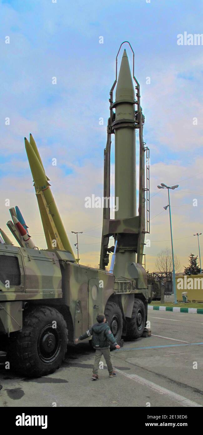 little boy beside huge short-range ballistic missile (Shahab-2) displayed at the 'Authority 40' military exhibition in Tehran Stock Photo