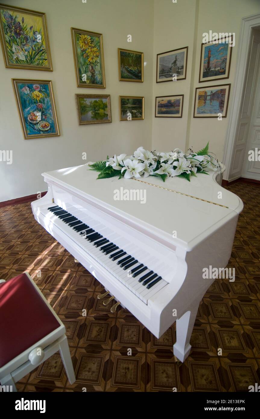 White piano in the room with paintings. The interior of the palace ...
