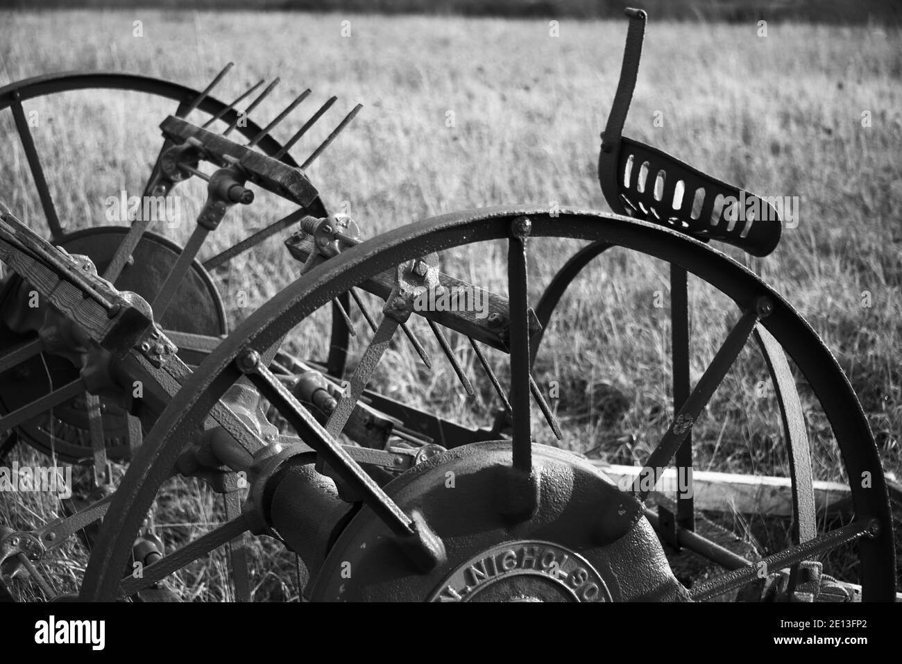 Old farming machinery in field, horse drawn 1800s tedder black and