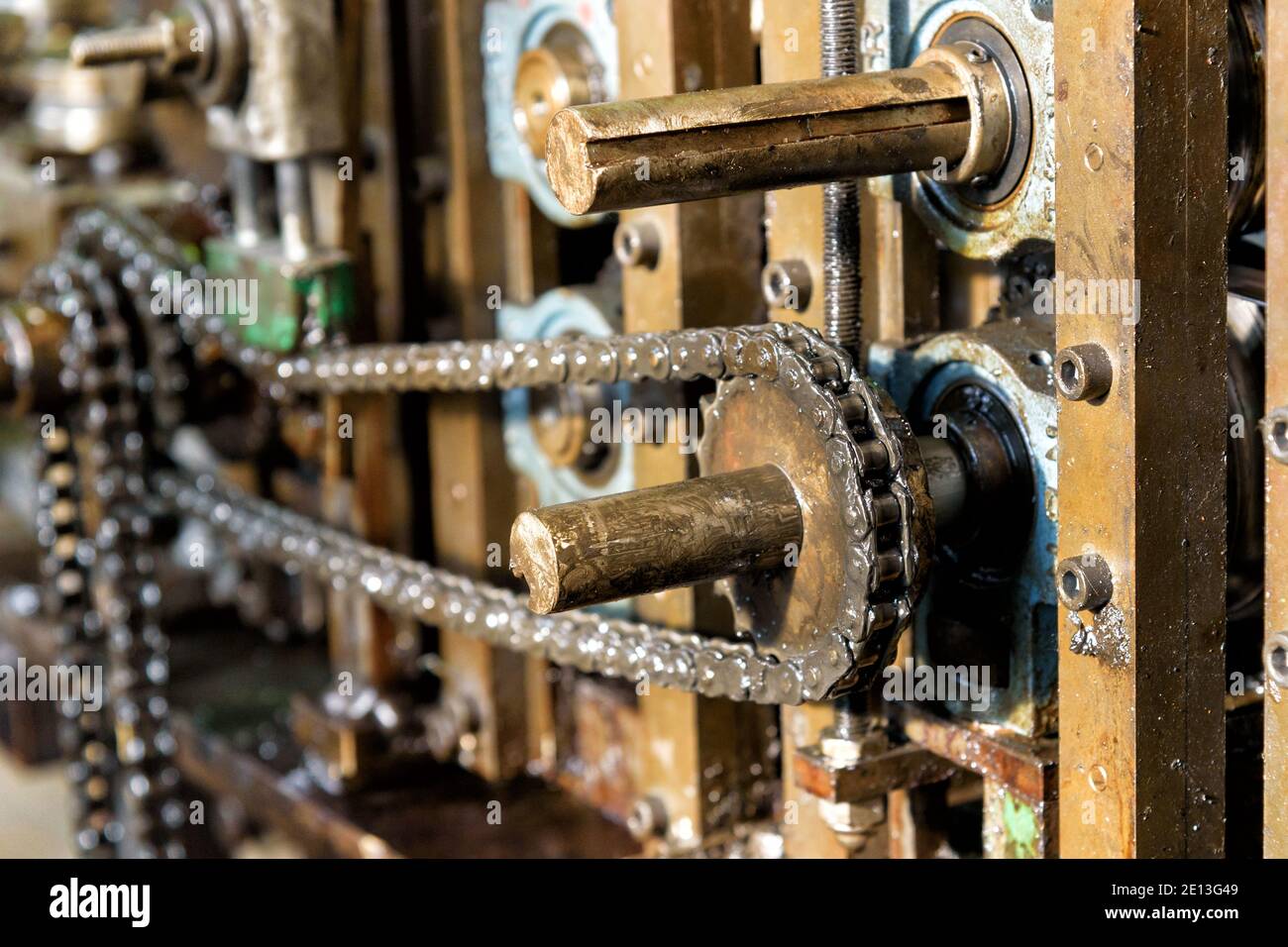Close up on the master drive chain on industrial machinery showing the toothed gear and sprockets in detail Stock Photo