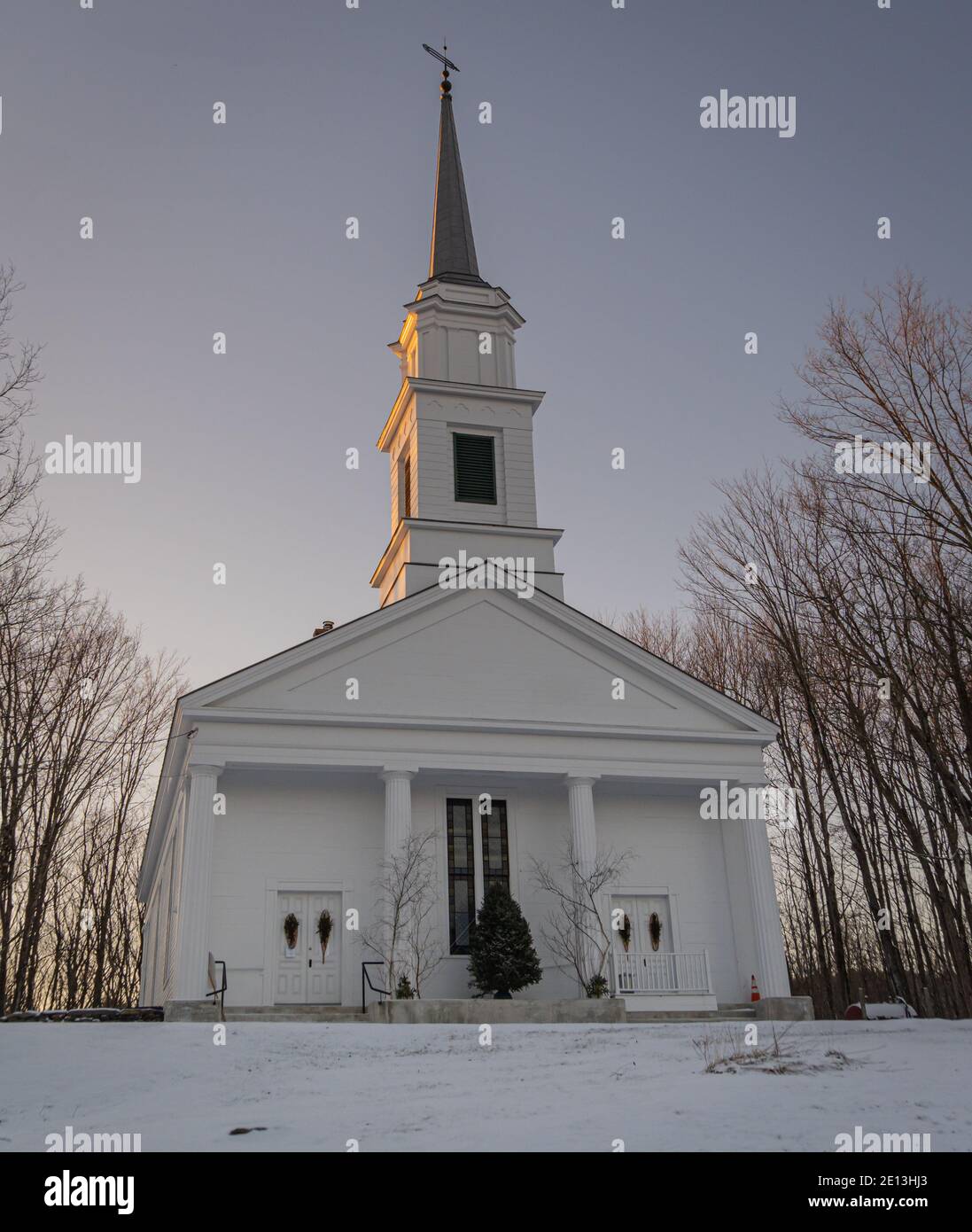 Classic New England white church on village green on a winter evening Stock Photo