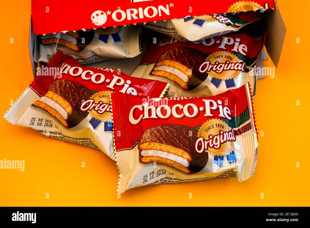 Tambov, Russian Federation - October 30, 2020 Orion Choco-Pie snack cakes spills out of the box. Yellow background. Stock Photo