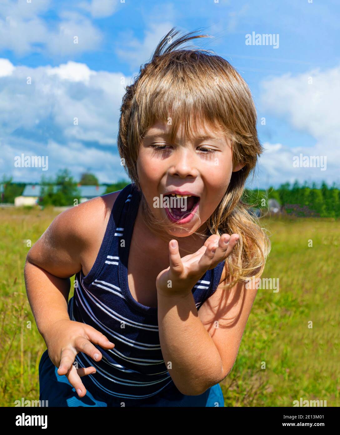 Child's emotions. The boy is dancing. Facial expression joyful happy. Hands in motion. Stock Photo