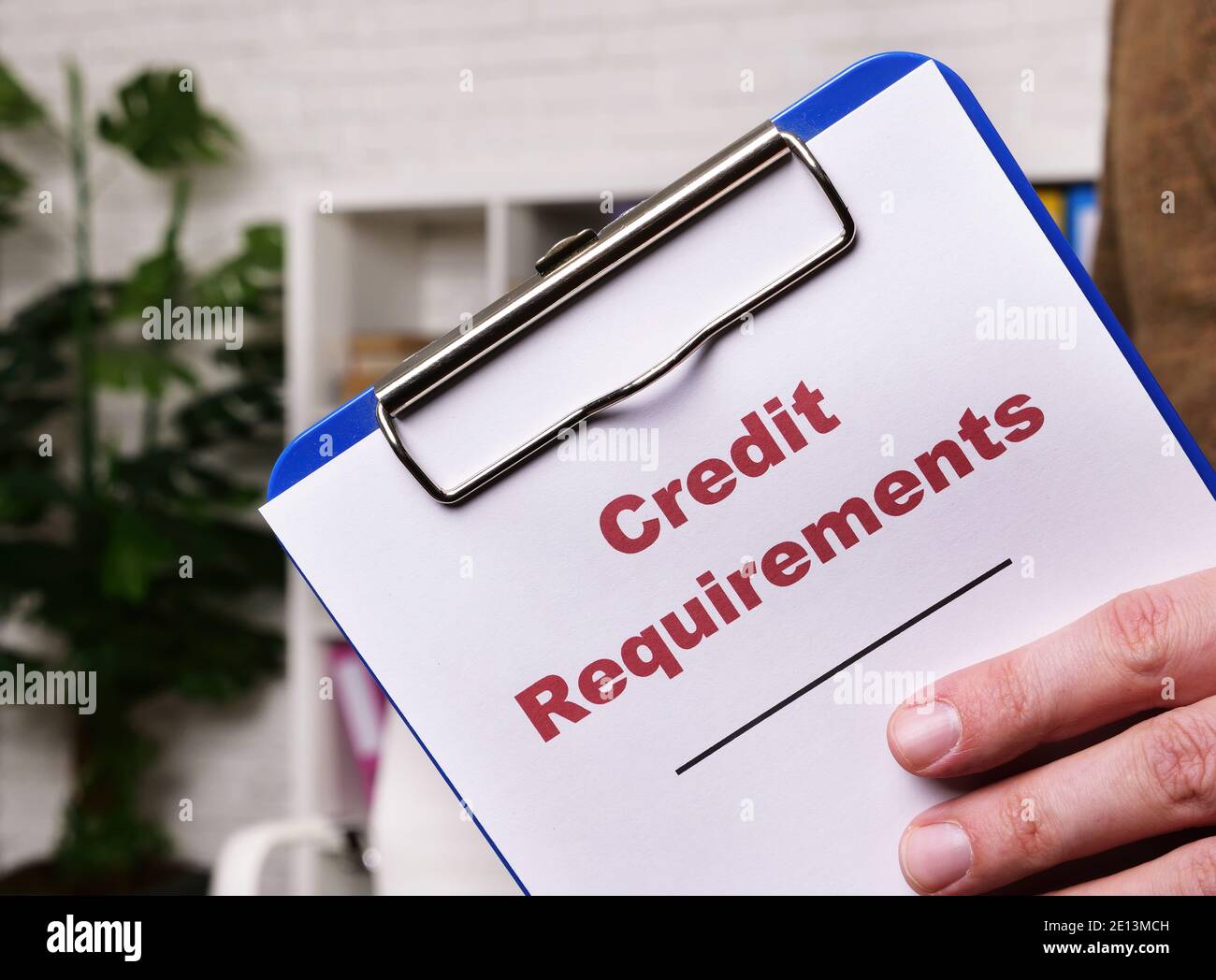 Credit requirements list with clipboard in the hands. Stock Photo