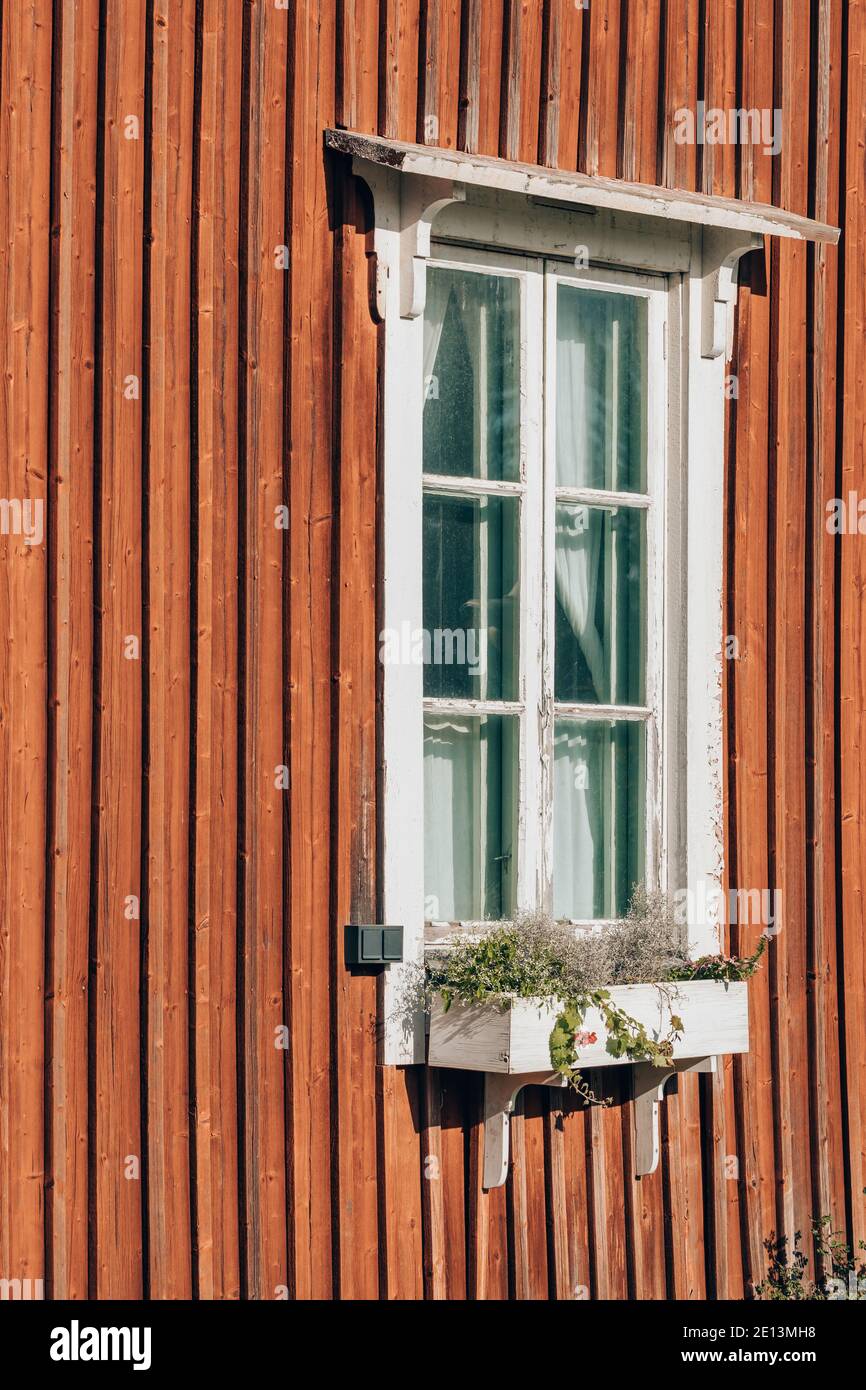 Window on the wall of the red wooden house in Finland Stock Photo
