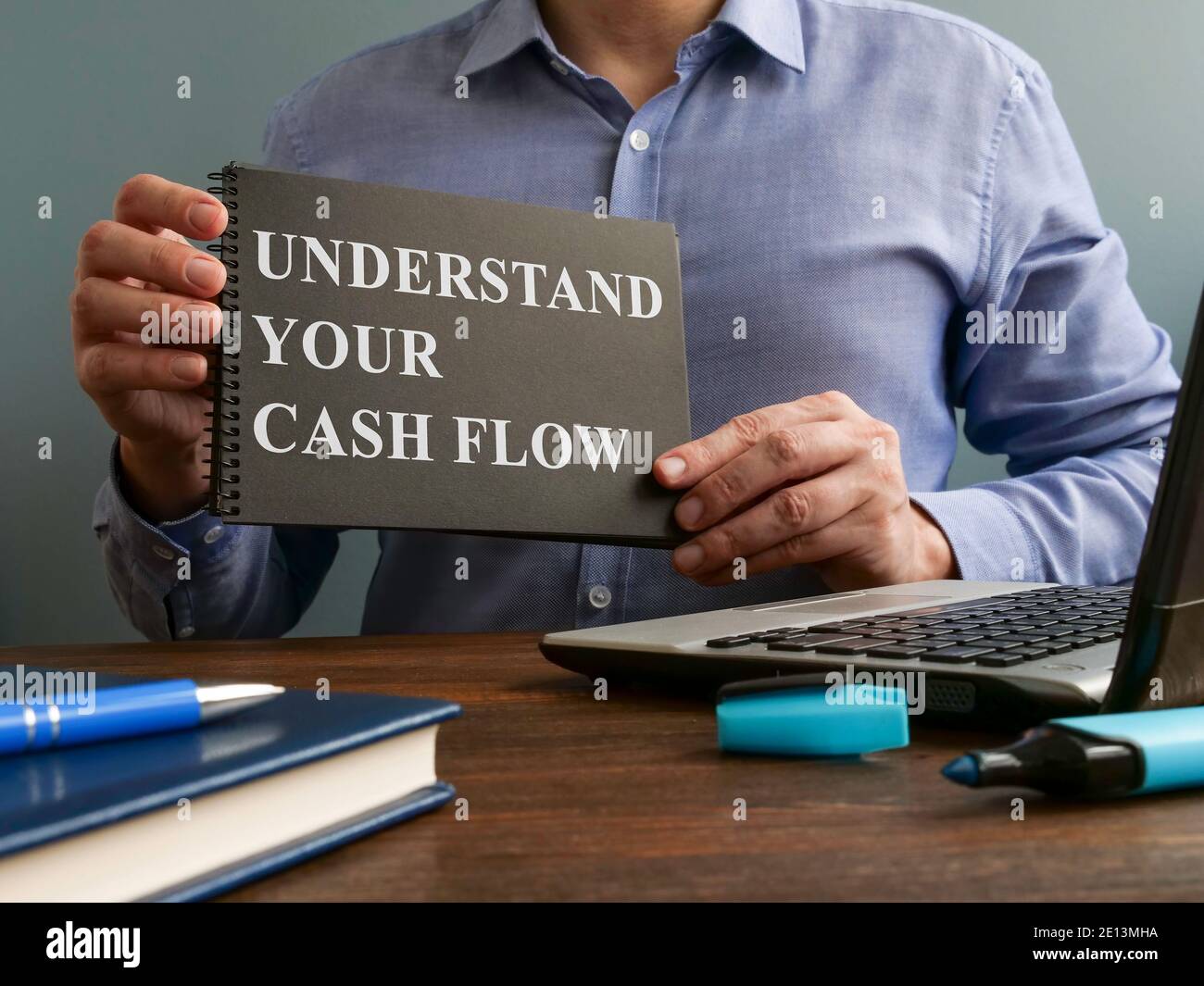 Man shows Understand your cash flow sign on the page. Stock Photo