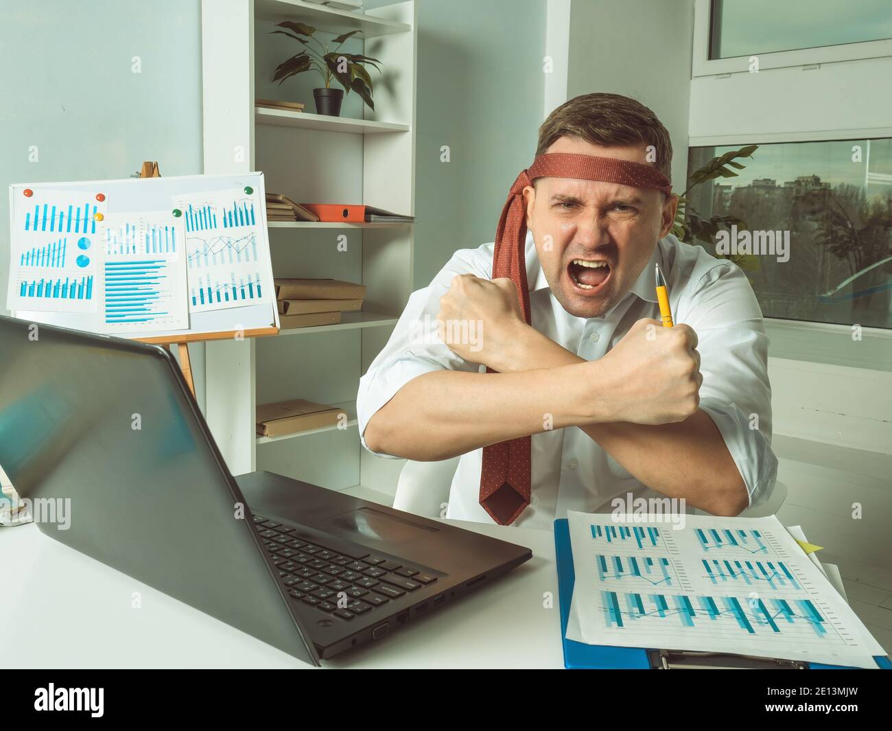 Angry aggressive employee at the table in the office. Stock Photo