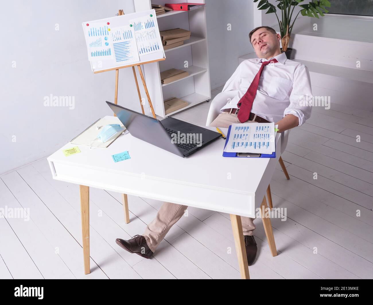 Tired worker sleeping alone at night in the office at work. Stock Photo