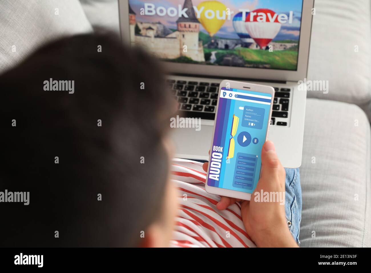 Man using audiobook application on modern smartphone at home Stock Photo