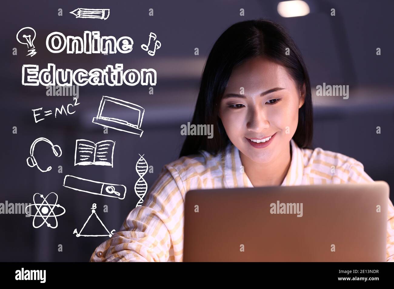 Text 'Online education' and young Asian student with laptop learning at home Stock Photo