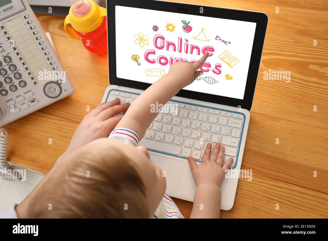 Young mother with baby using laptop for online learning at home Stock Photo