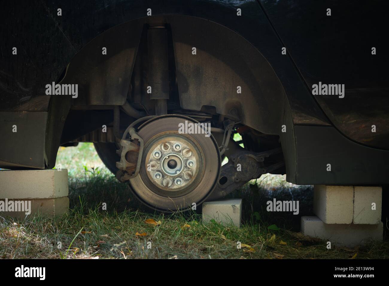 Close up of car on bricks outside. Concept of stolen vehicle wheels