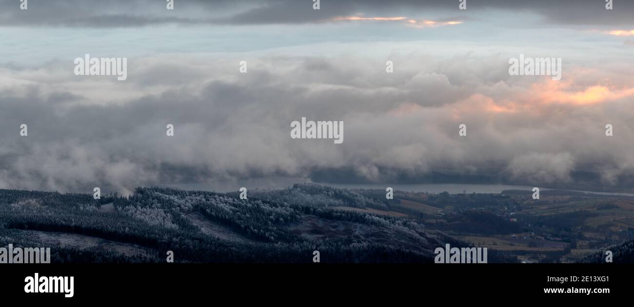 panorama of the mountain landscape in winter over which heavy snow clouds are flowing Stock Photo