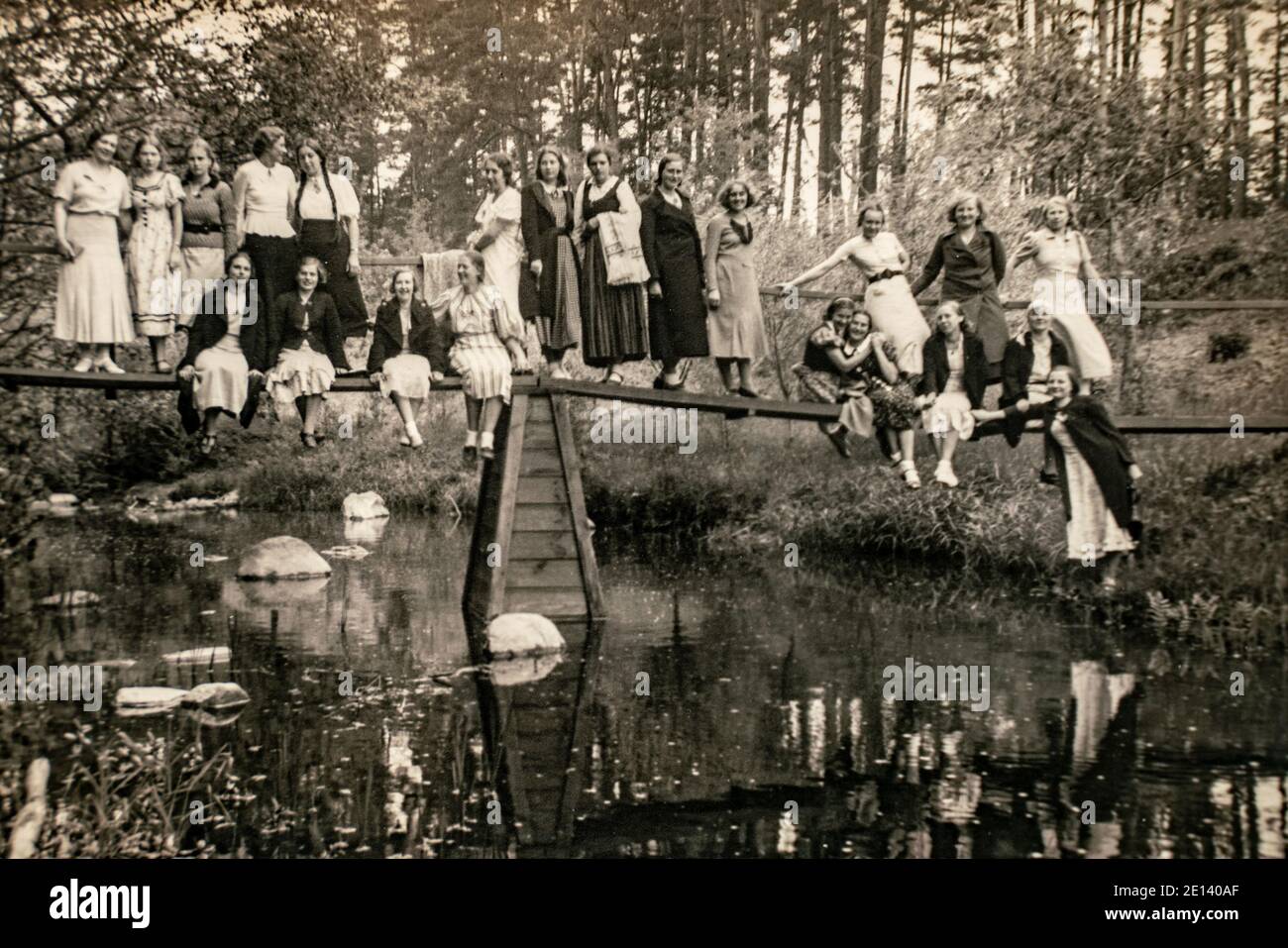 Latvia - CIRCA 1930s: Group photo on bridge in forest. Vintage archive Art deco era photo Stock Photo