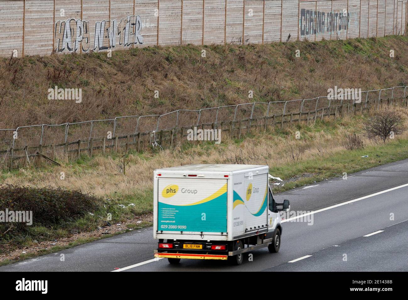Shepshed, Leicestershire, UK. 4th January 2021. A phs group van passes coronavirus themed graffiti beside the M1 motorway.  Credit Darren Staples/Alamy Live News. Stock Photo