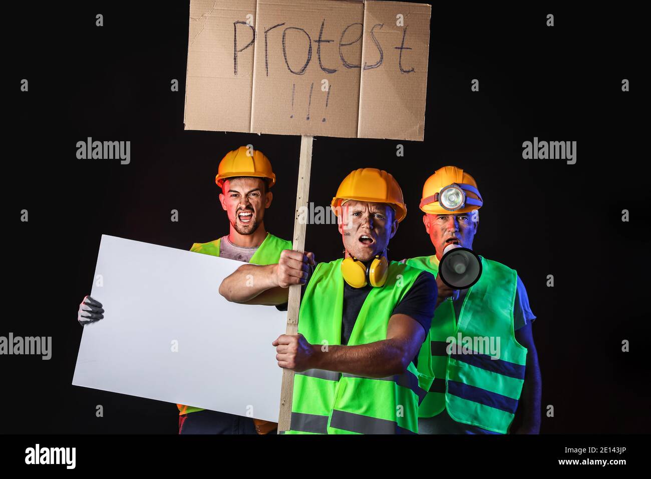 Protesting miner men with placards on dark background Stock Photo