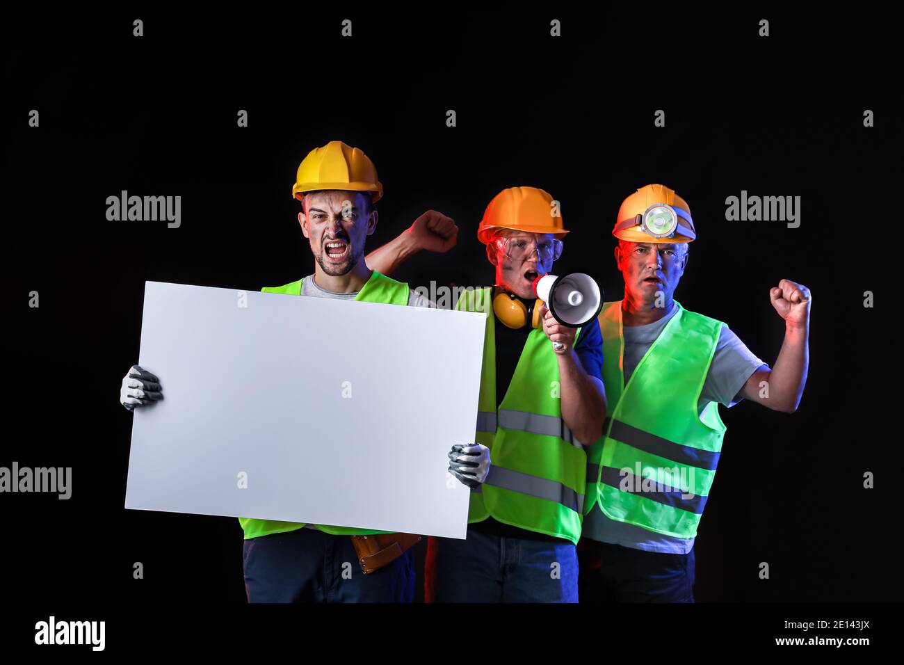 Protesting miner men with placard on dark background Stock Photo