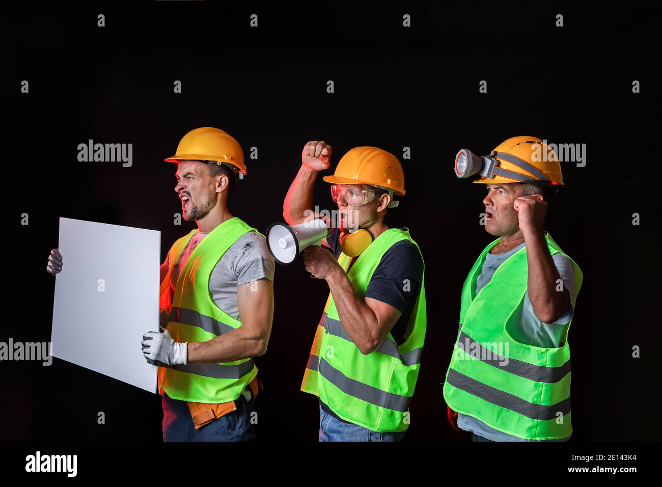 Protesting miner men with placard on dark background Stock Photo