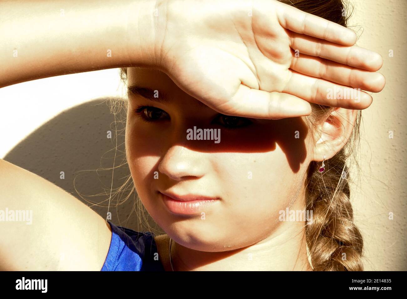 Teenage girl shading her eyes young teenager Stock Photo