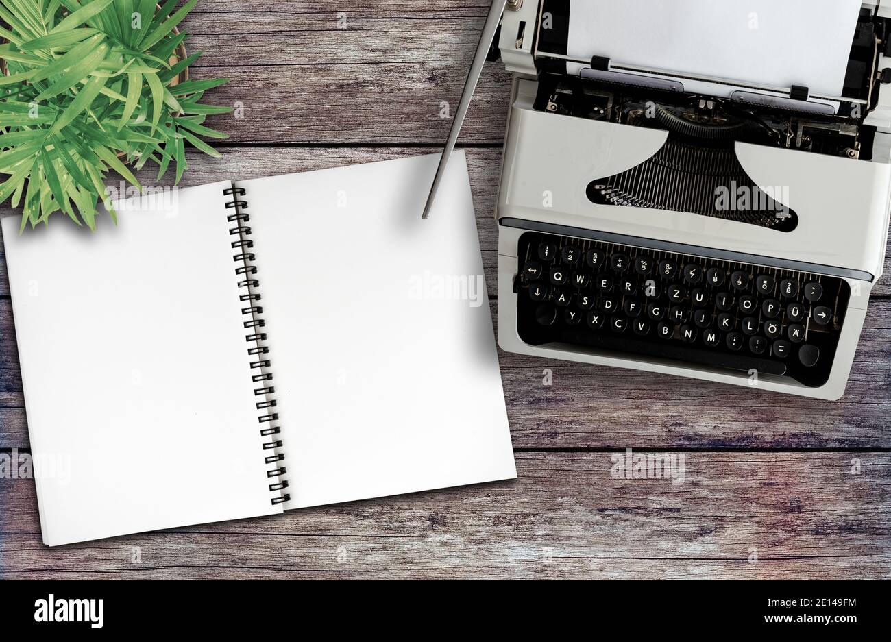 directly above view of old typewriter and spiral notepad on rustic wooden desk, blogging and journalism concept Stock Photo