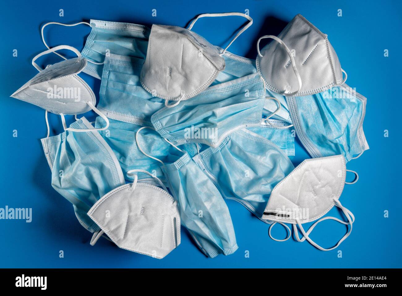 KN95 or FFP2 masks and surgical face masks used on blue background. Medical mask for Covid-19 protection - ecological recycling concept Stock Photo
