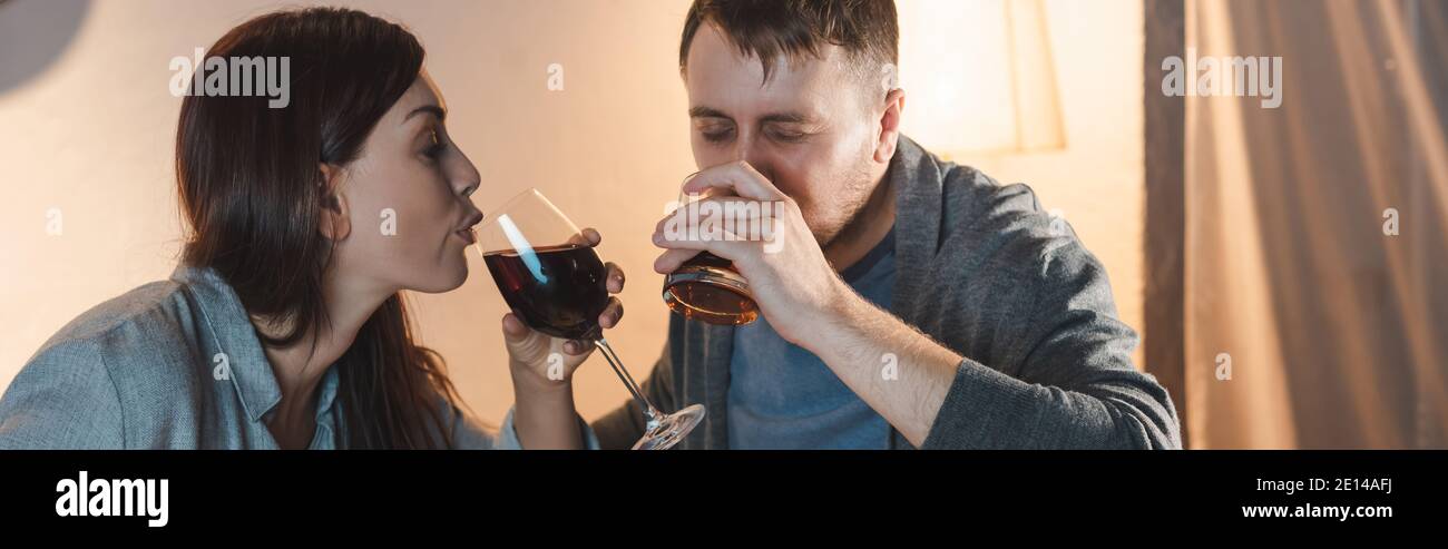 alcohol-addicted husband and wife drinking at home together, banner Stock Photo
