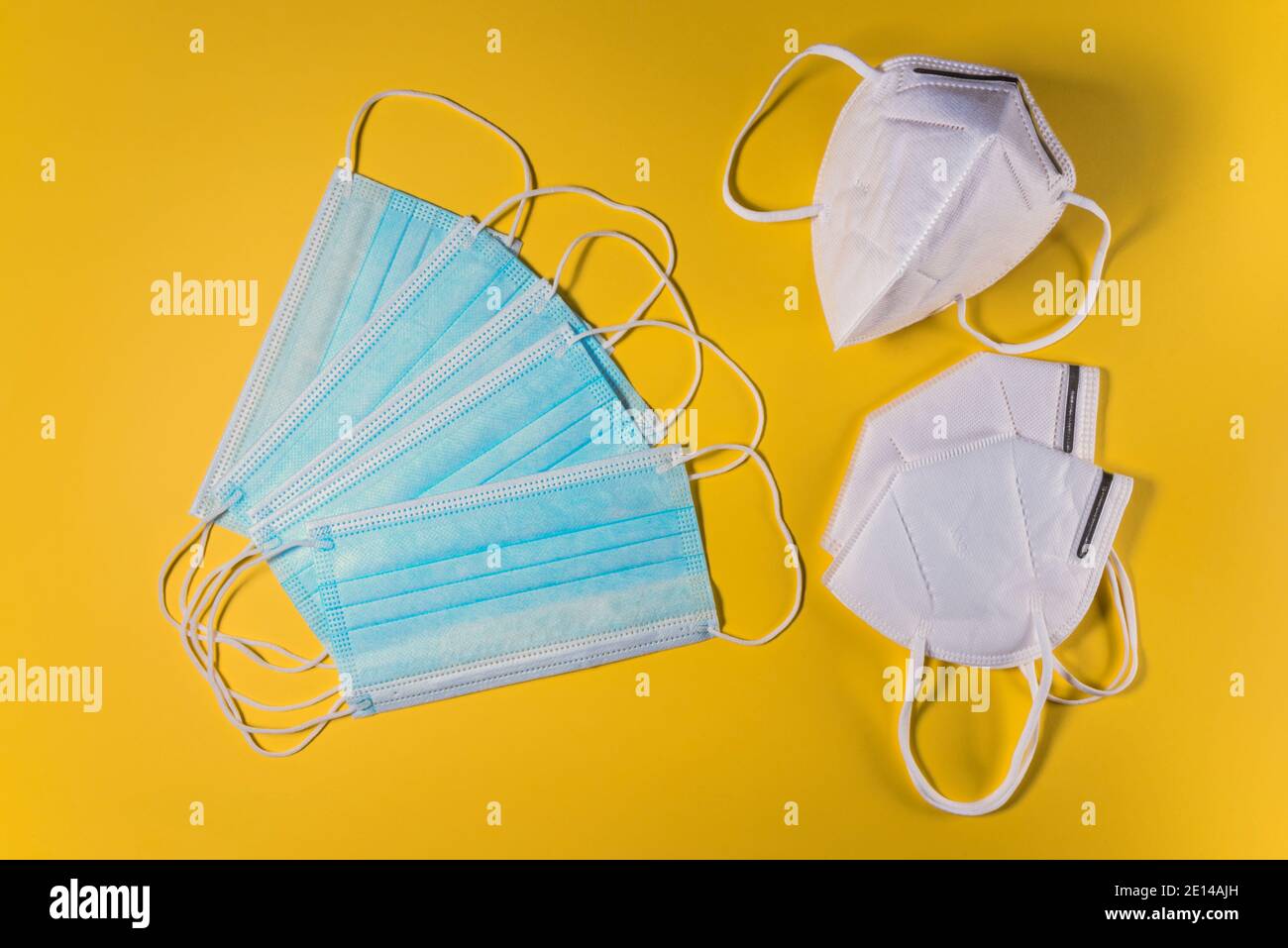 KN95 or FFP2 mask and surgical face mask on yellow background. Medical mask for Covid-19 protection to prevent coronavirus pandemic Stock Photo
