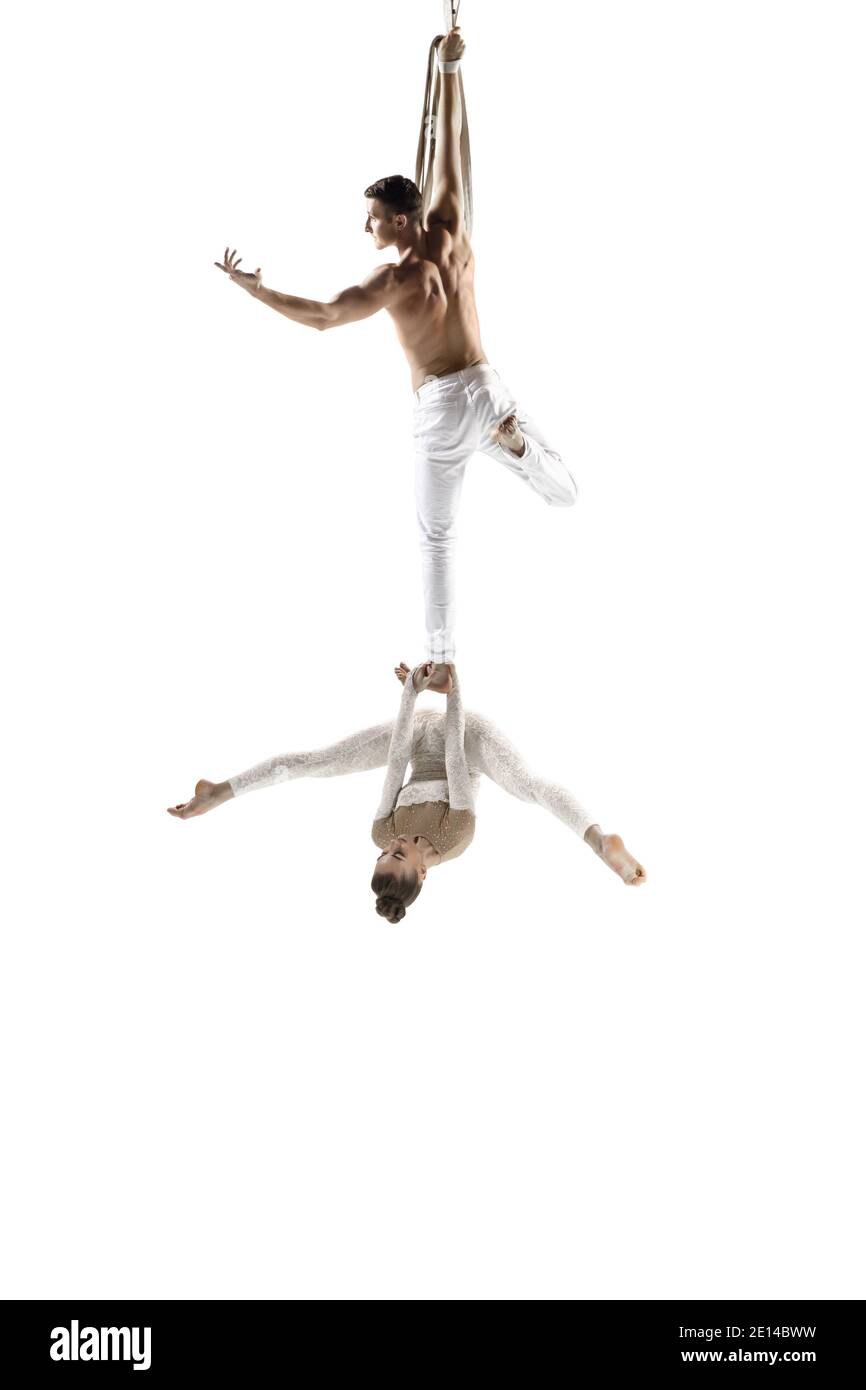 Catching. Couple of acrobats, circus athletes isolated on white studio