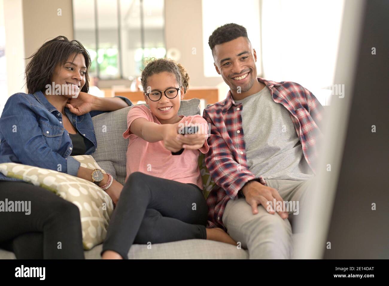 happy family sitting in sofa and watching tv together Stock Photo - Alamy