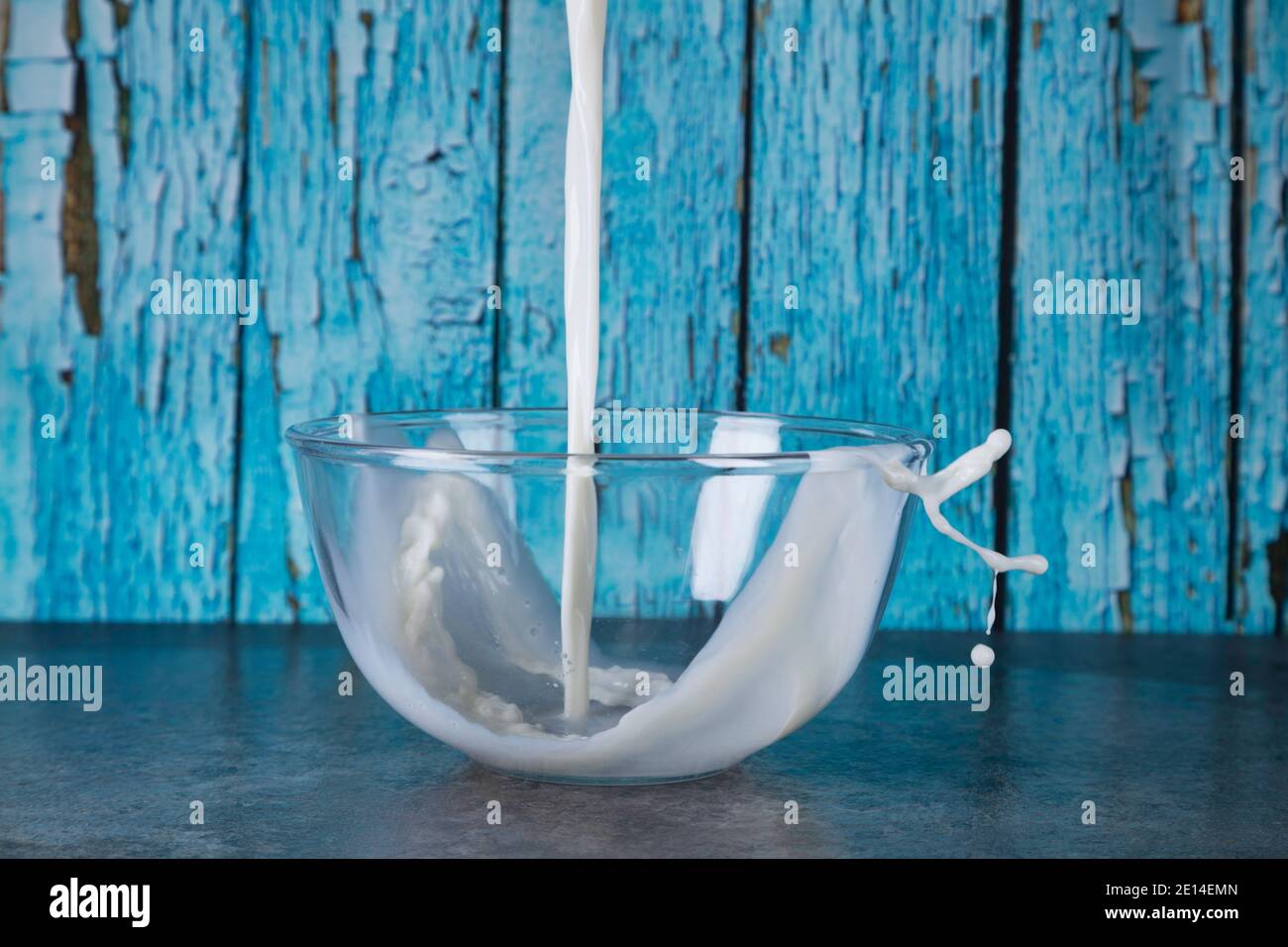 Pouring milk into a bowl in the kitchen. Stock Photo