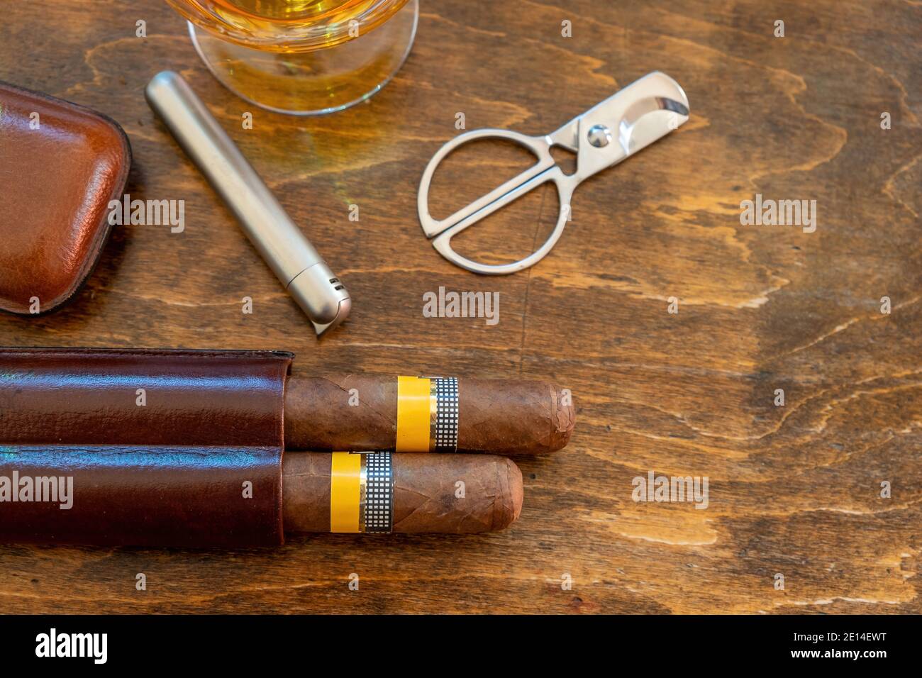 Tobacco and alcohol. Cigar and brandy on a wooden table, top view. Cuban quality brand cigars and rum, smoking and drinking luxury lifestyle Stock Photo