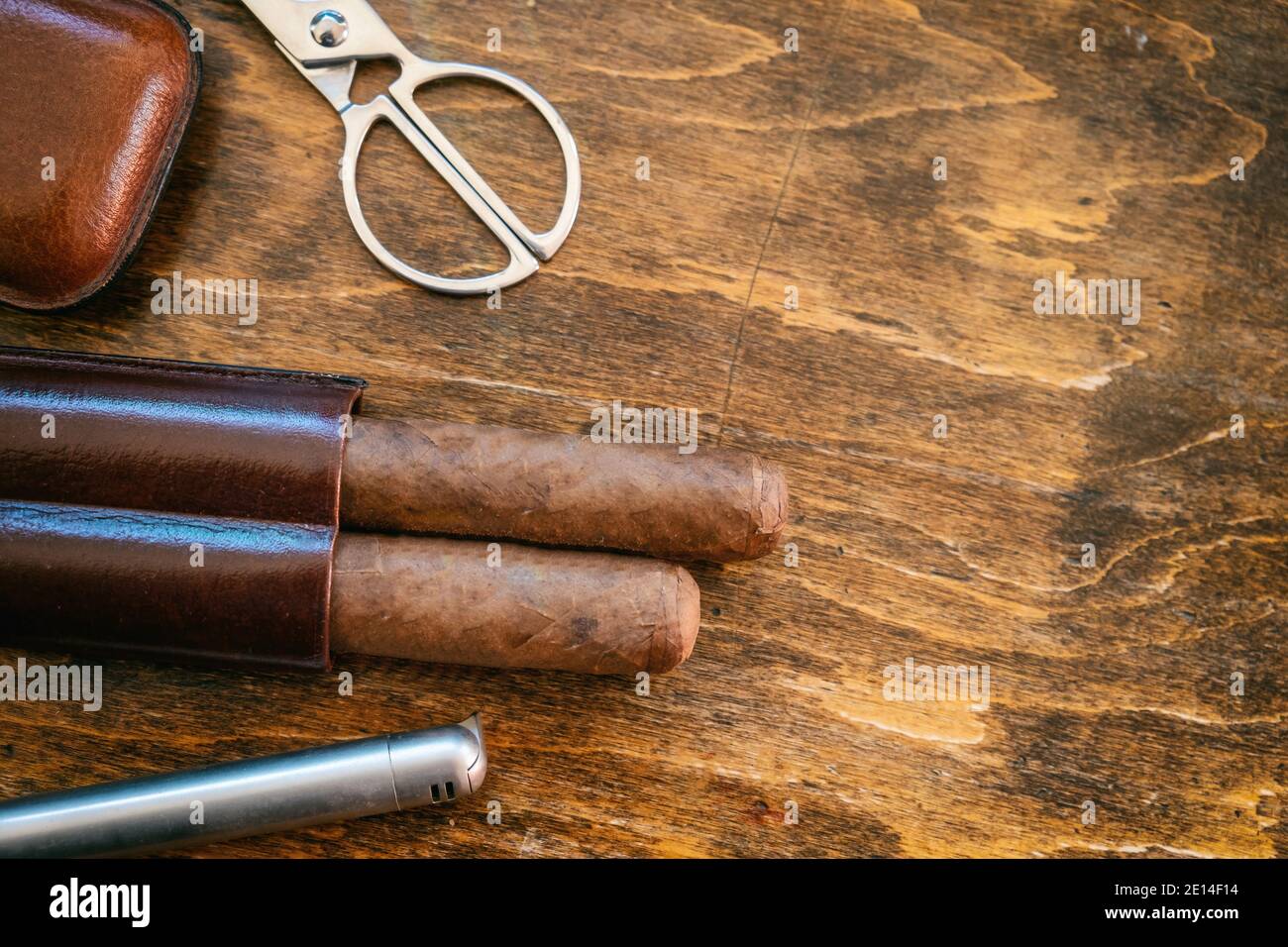 Cigar and accessories on a wooden table, closeup view. Cuban quality cigars tobacco smoking luxury lifestyle. Top view, template copy space Stock Photo
