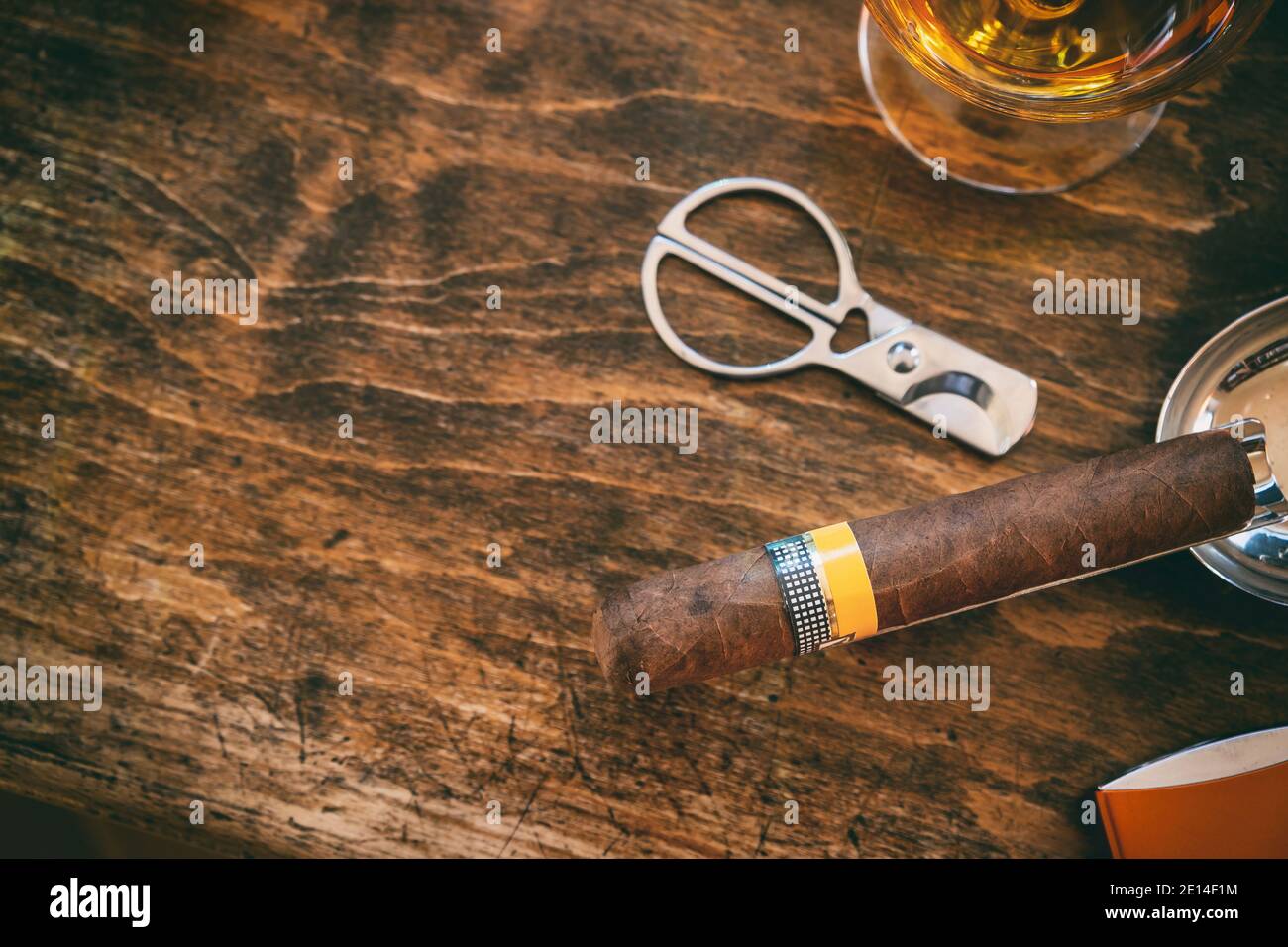 Tobacco and alcohol. Cigar and brandy on a wooden table, top view. Cuban quality brand cigar and rum, smoking and drinking luxury lifestyle Stock Photo