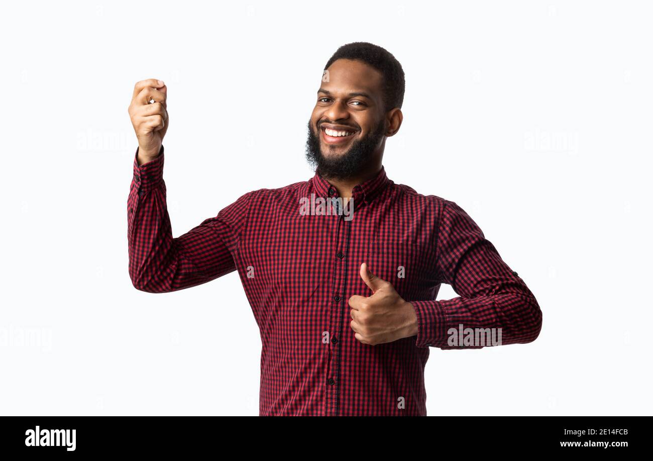 Cheerful African Guy Gesturing Thumbs-Up Approving Taste Over White Background Stock Photo