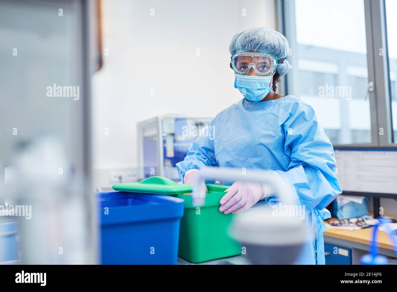 African woman works as a researcher in the laboratory with protective clothing on Covid-19 vaccine for coronavirus pandemic Stock Photo