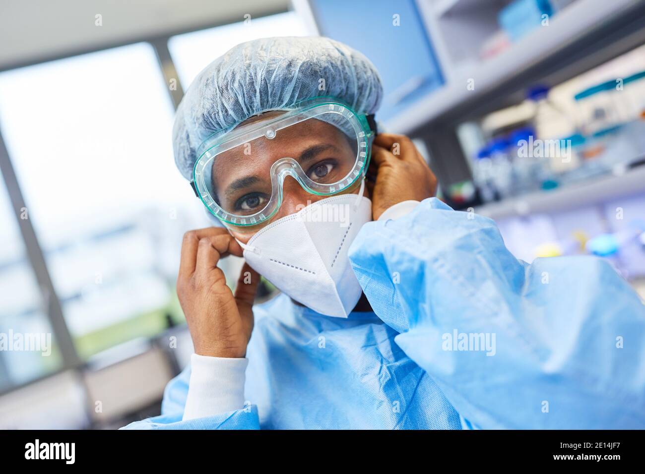 Woman with protective clothing as a researcher in the biochemistry laboratory is looking for Covid-19 vaccine in the coronavirus pandemic Stock Photo