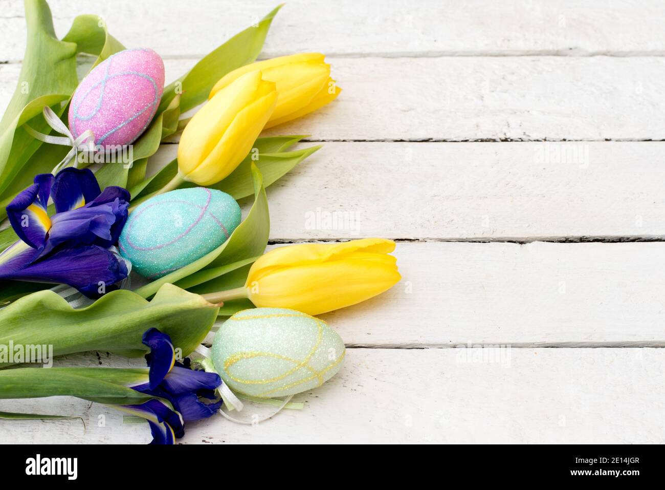 Easter eggs and sprind flowers on wooden planks with a copy space Stock Photo