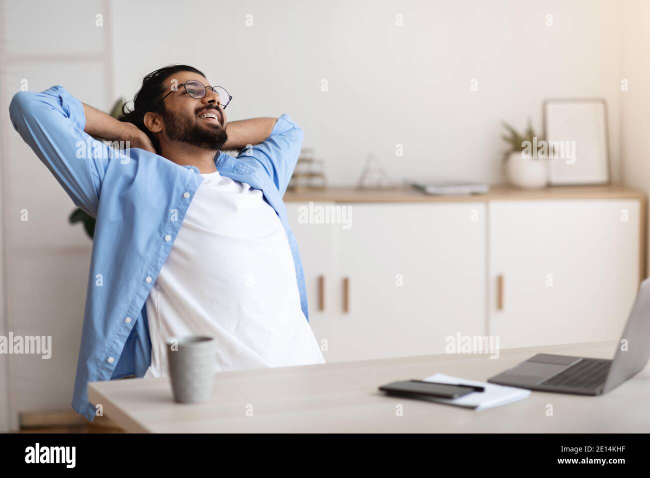 Cheerful Arab Freelancer Guy Leaning Back In Chair, Relaxing After