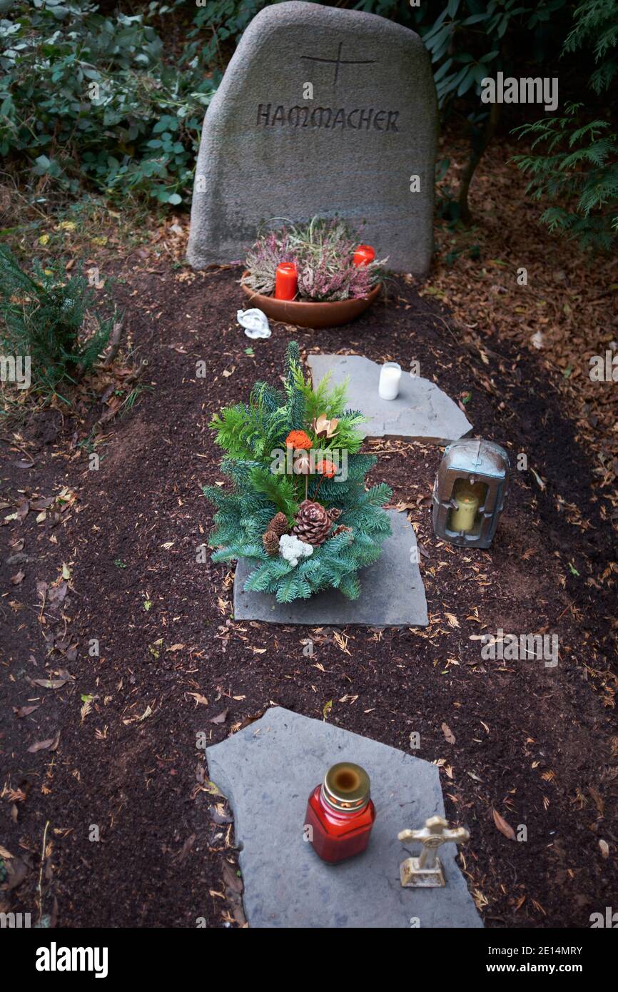 Grabstelle mit einem Gesteck, Grableuchte, Grabstein und Kreuz. Stock Photo