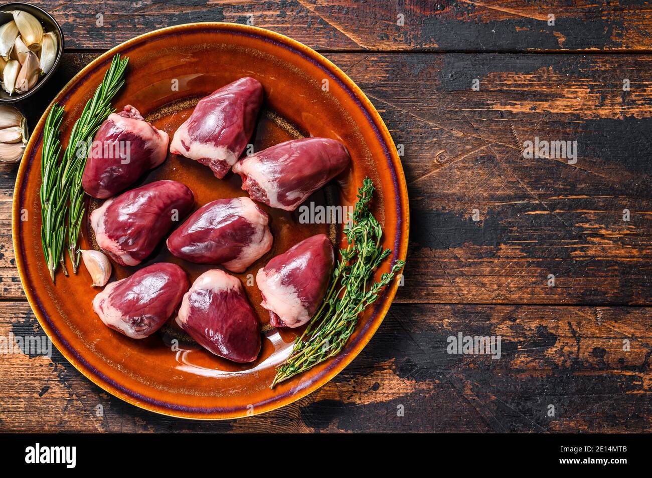 Fresh Raw turkey hearts offal giblets with thyme and rosemary. Dark