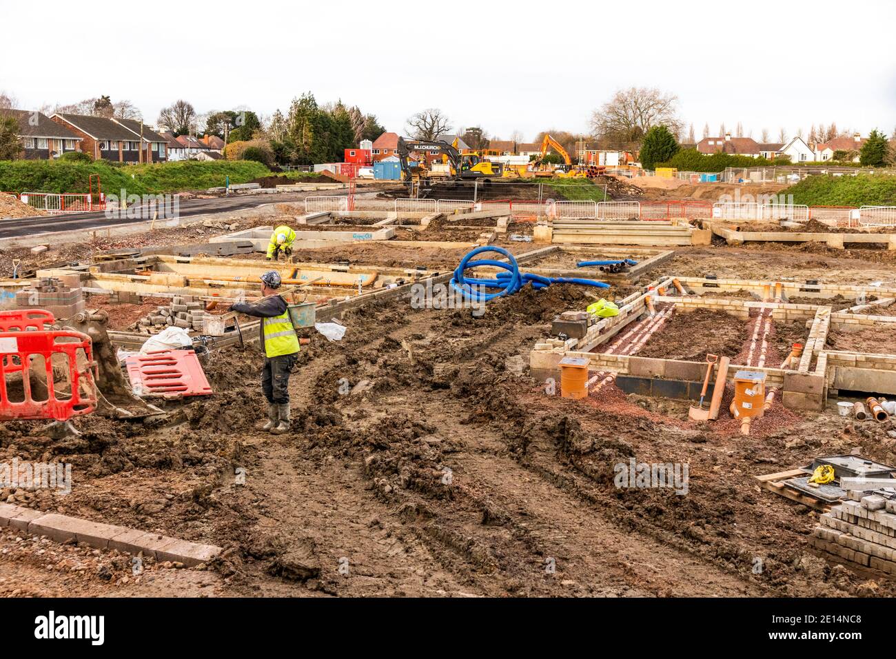 Builders on a muddy site laying foundations for new homes in Kingsholm, Gloucester UK Stock Photo