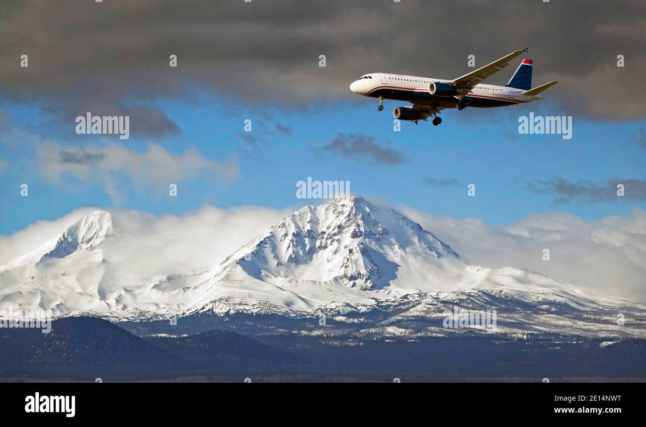 A 737 pasenger jet preparing to land at Redmond Airport, Oregon. Flying past North Sister Peak, 10,051 feet in elevation, in the central Oregon Cascade Mountains. Stock Photo